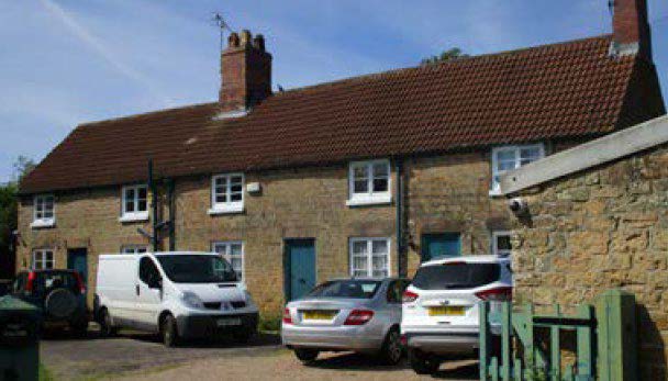 terraced houses with cars parked in the driveway.