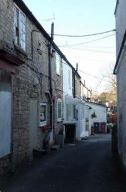 a narrow walkway between houses on either side.
