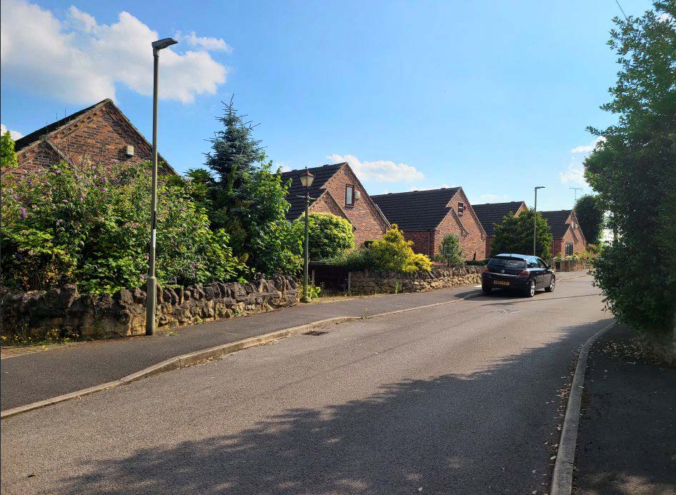 Housing along a street with trees.