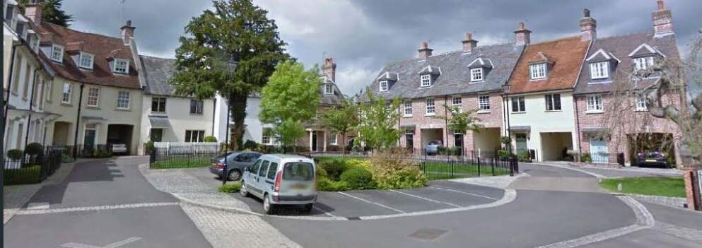 Neighbourhood of terraced houses with lots of greenery and a central green space.