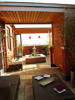 An outdoor patio on a balcony with furniture, creating a cosy space.