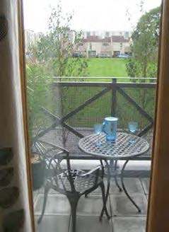 A small balcony with a garden table and chair.