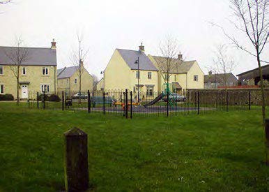 Houses in the background with a green space in the foreground including a local park.